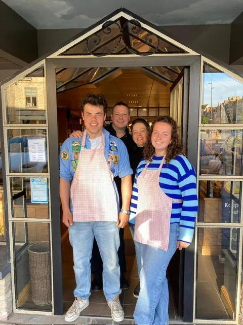 De familie Saint-Germain in de deuropening van de winkel